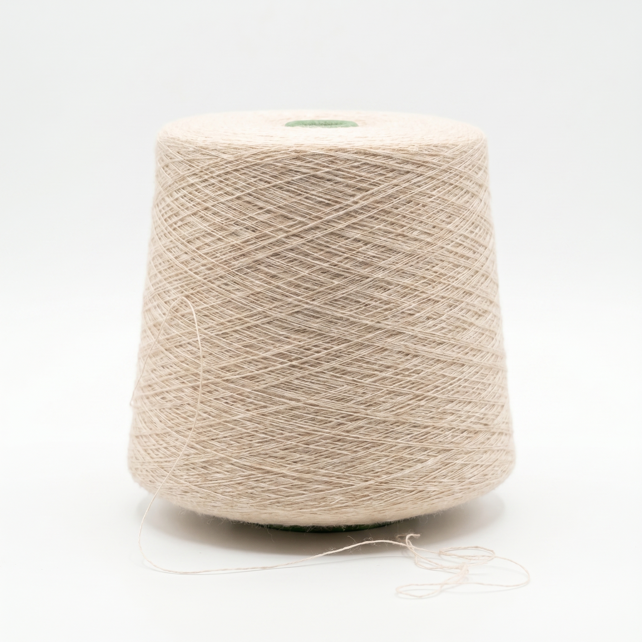 En stor cone med ljust beige garn mot en vit bakgrund.