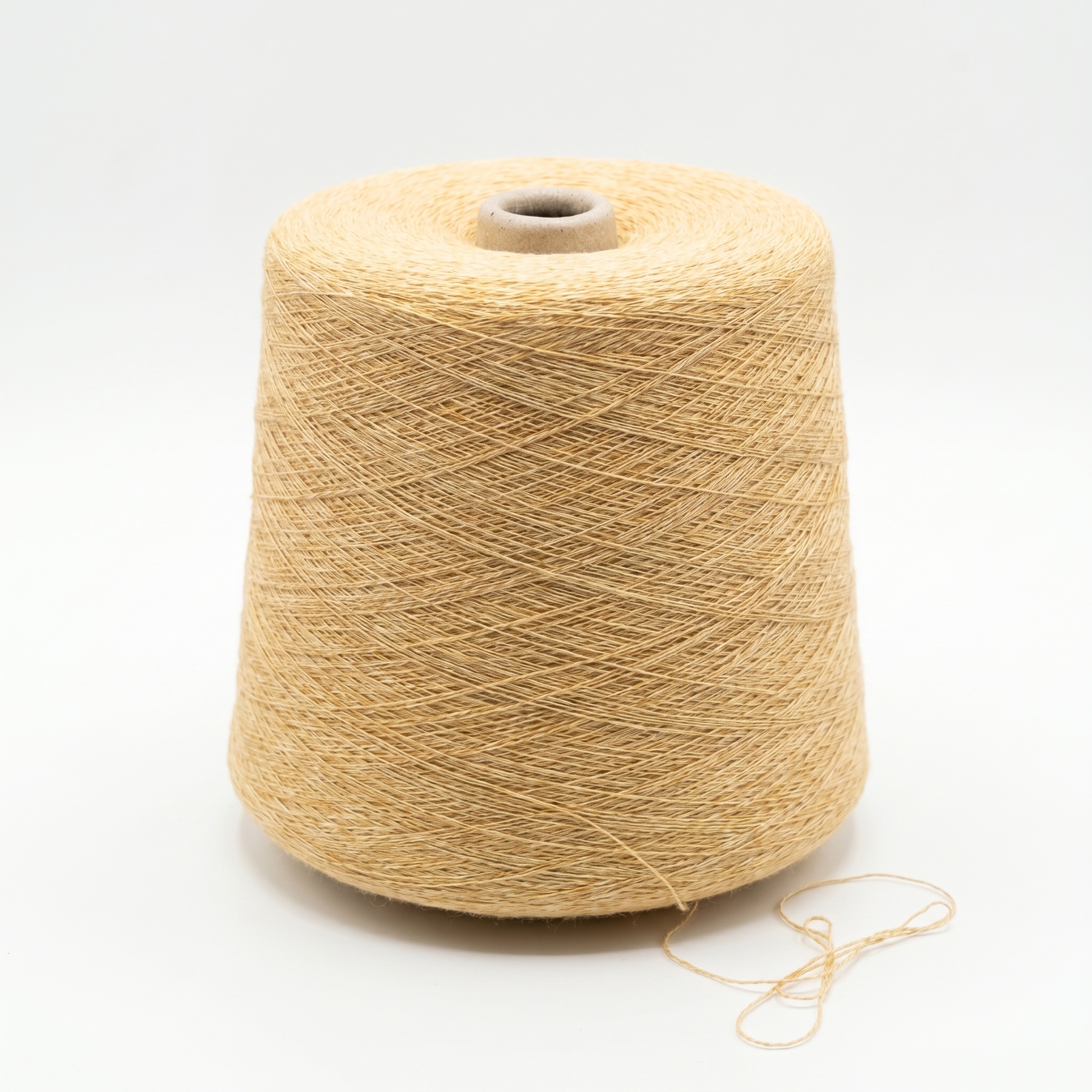 En cone med ljust beige, texturerat garn på en vit bakgrund.
