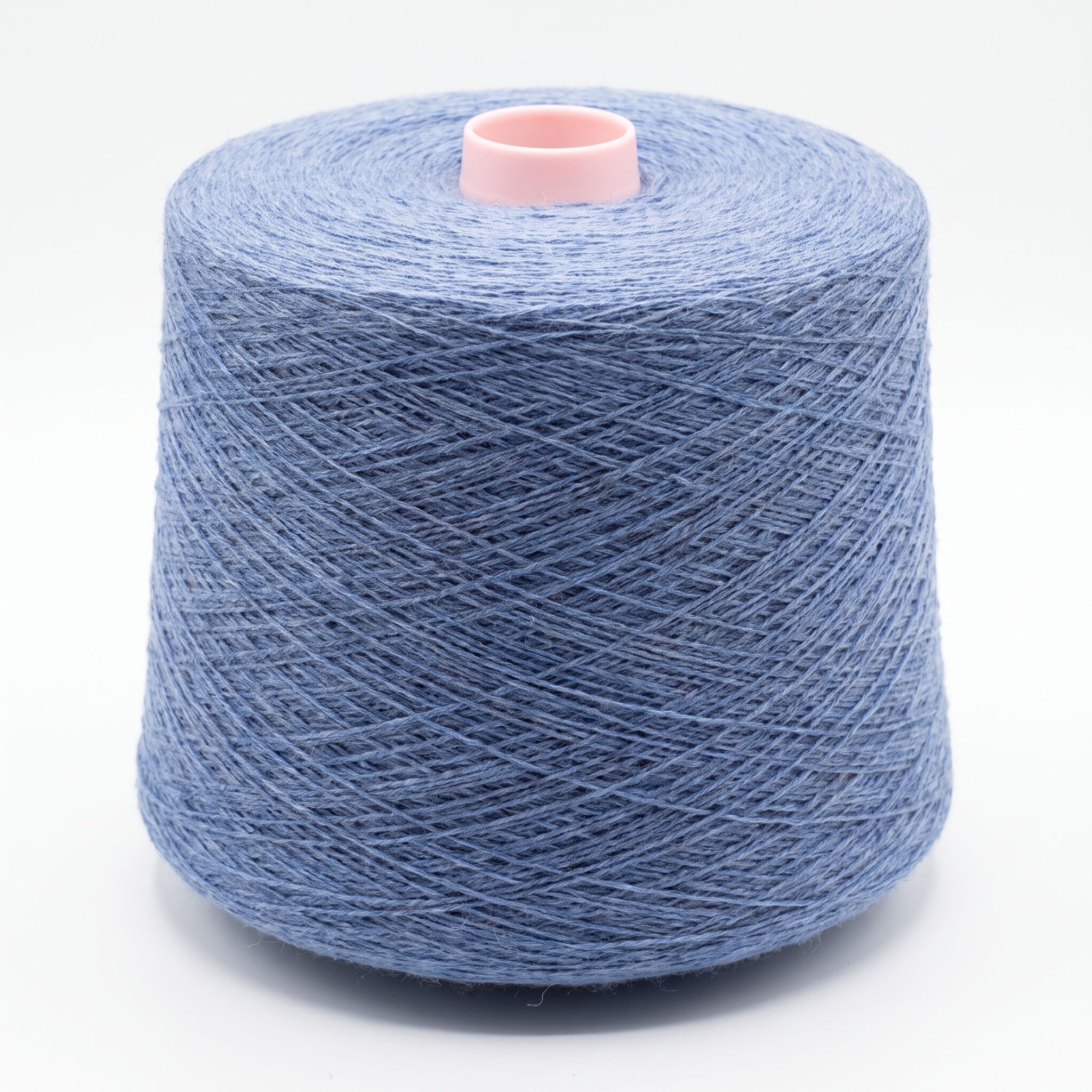 En stor cone med blått garn lindat runt en rosa kärna mot en vit bakgrund.