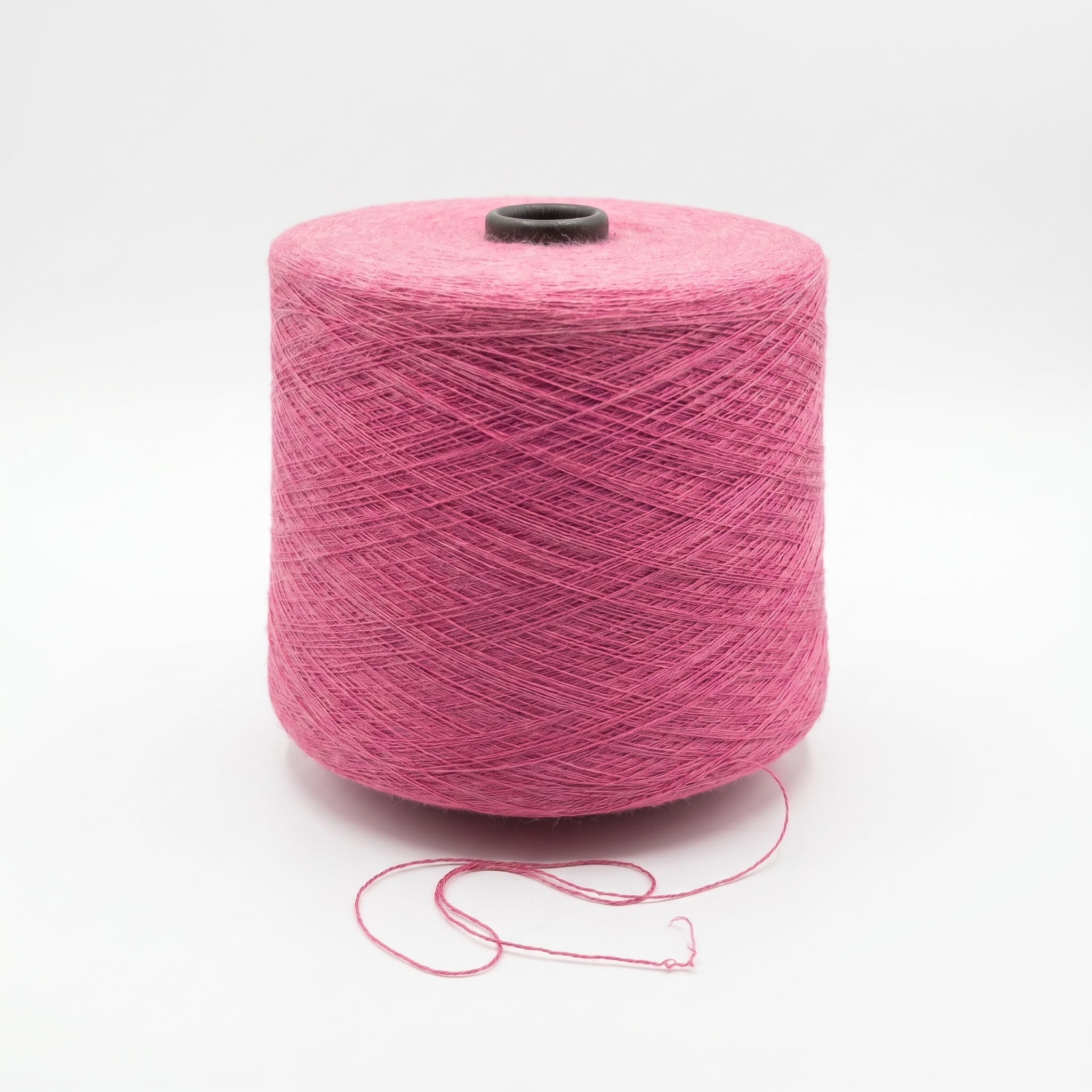 En cone med rosa garn på en vit bakgrund.