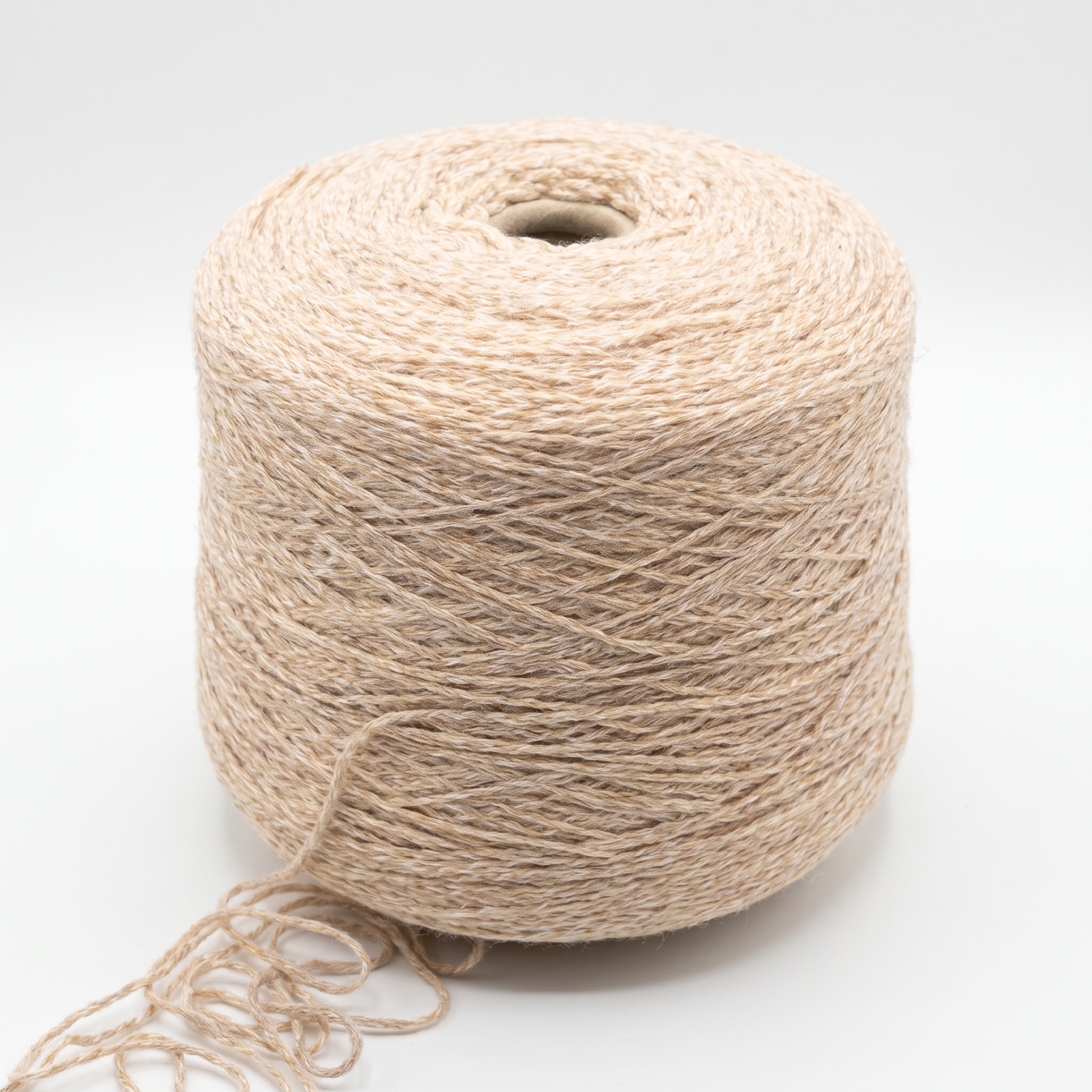 En stor cone med ljust, beige garn på en neutral bakgrund.