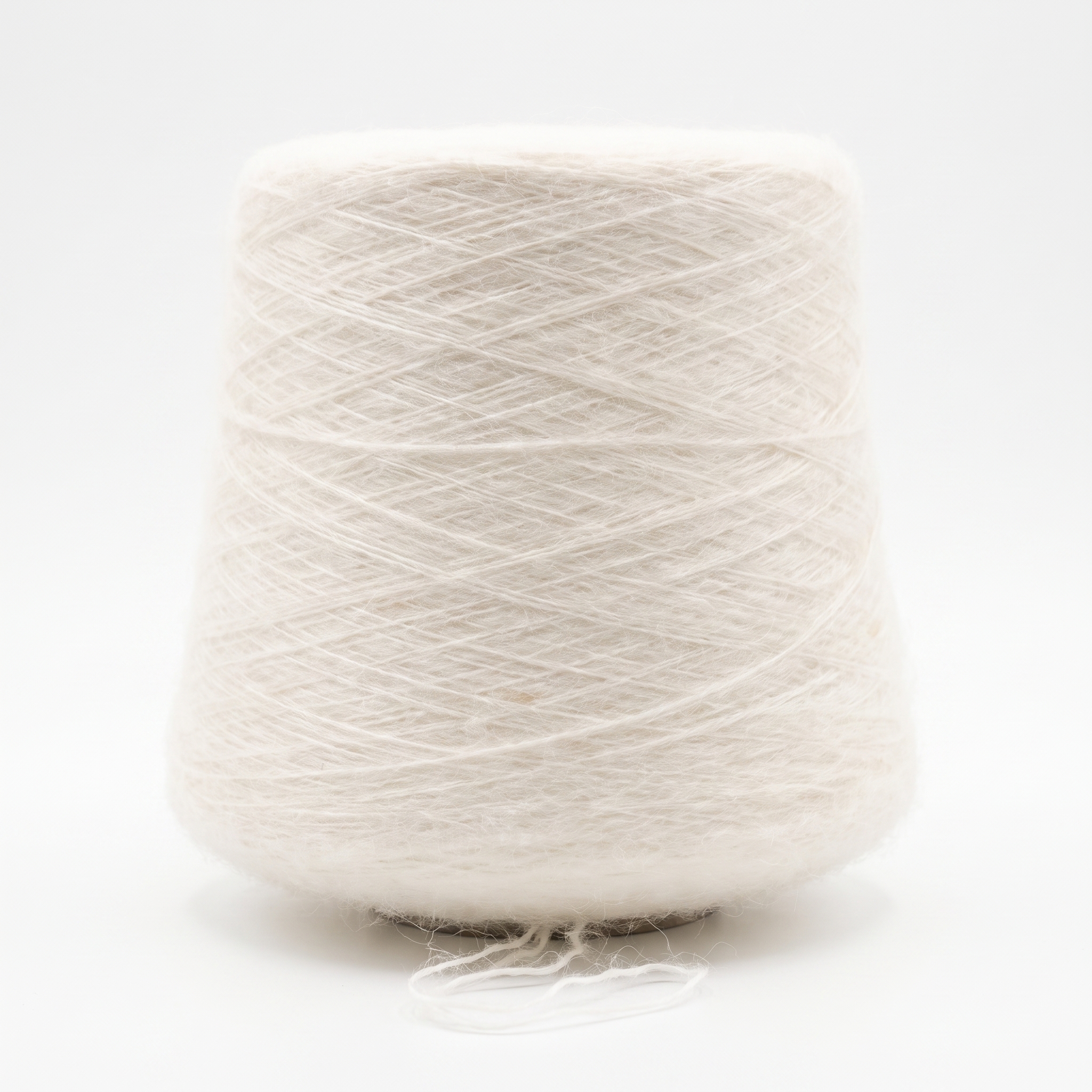 En stor cone med fluffigt, vitt garn på en vit bakgrund.