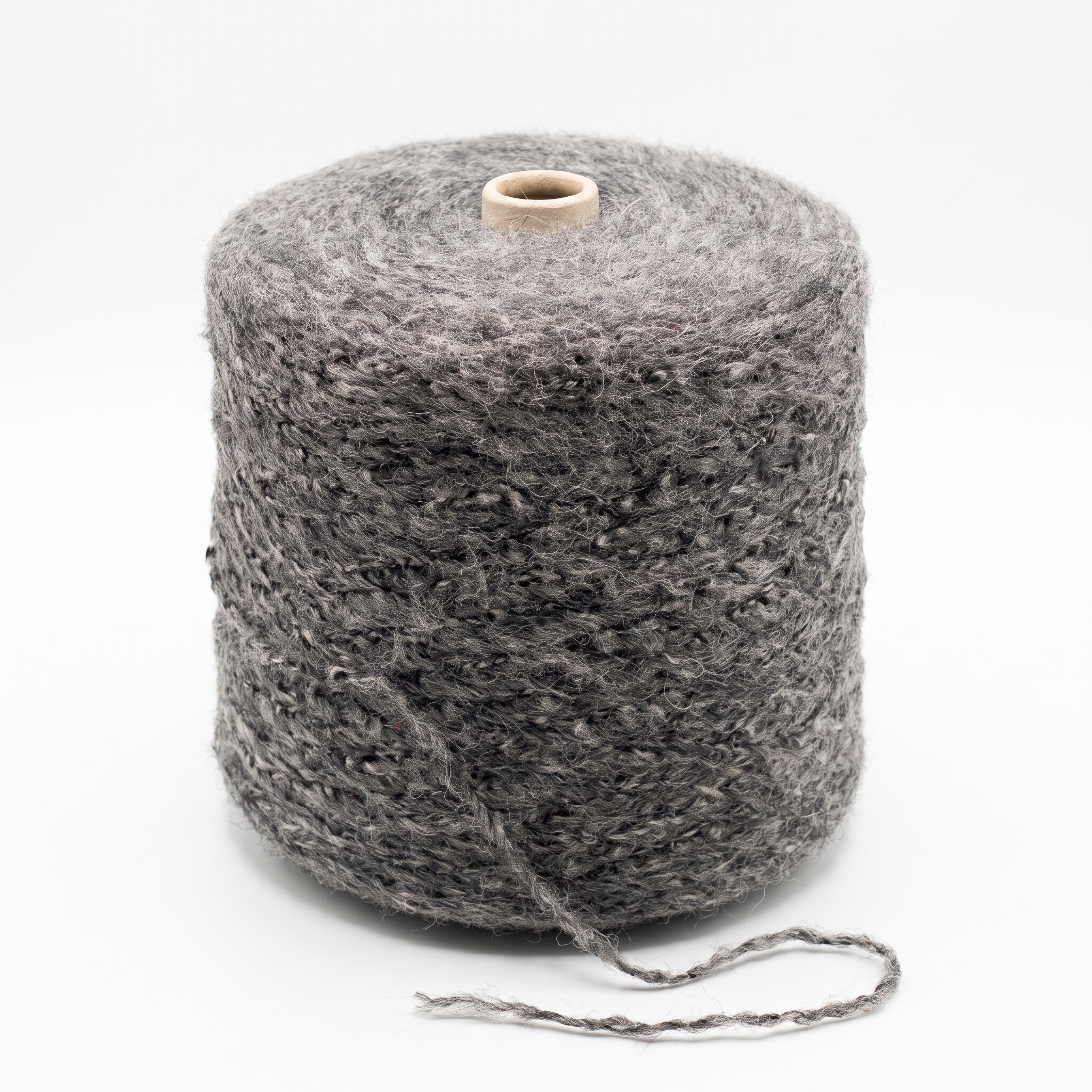 En stor cone av grått, texturerat garn står på en vit bakgrund med en lös ände.
