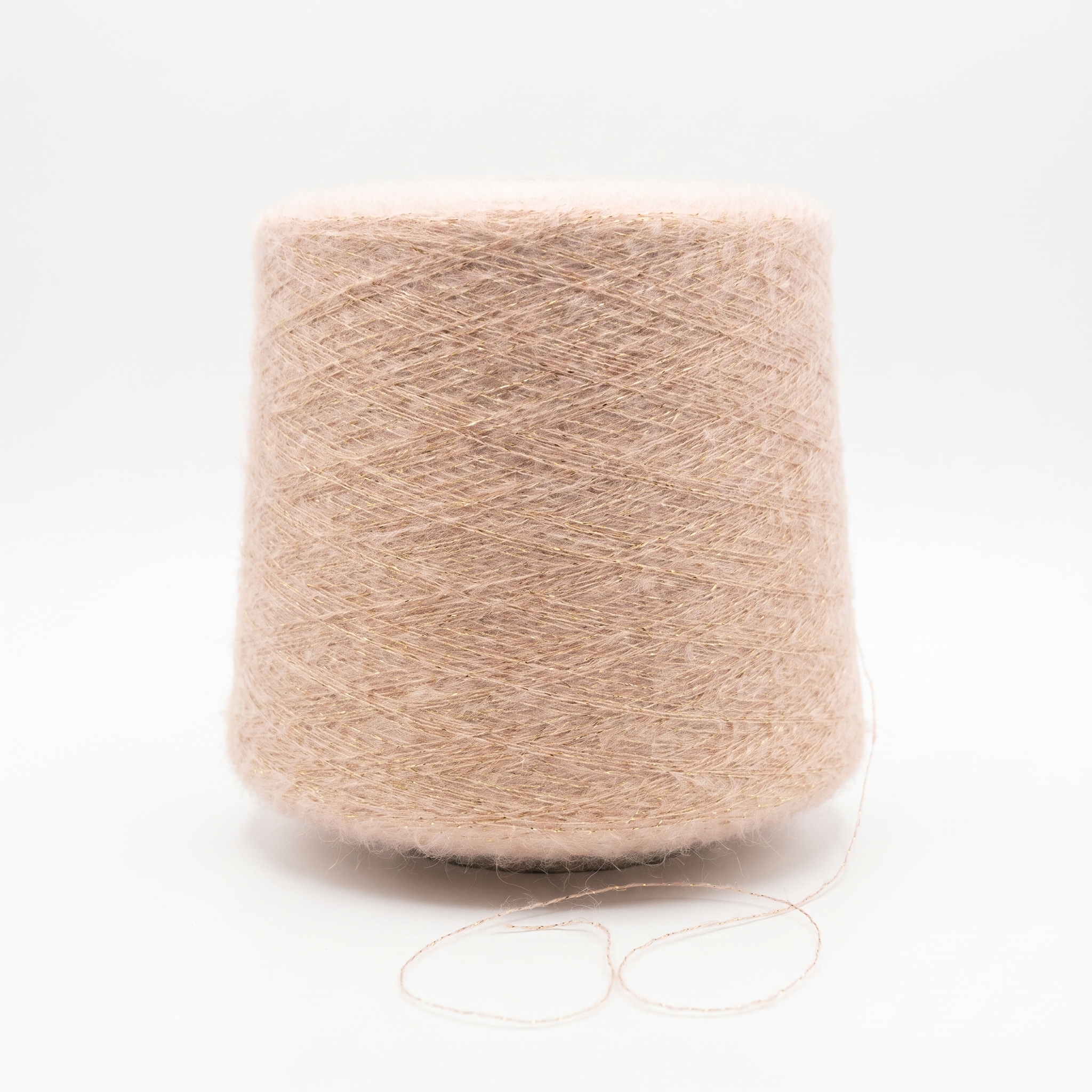 En stor cone med fluffigt ljusrosa garn med en fin glittertråd står på en vit yta.