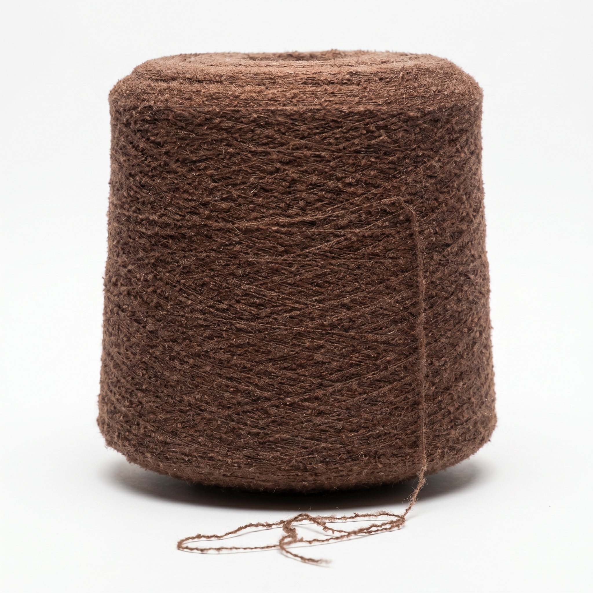 En stor cone av brunt, texturerat garn på en vit bakgrund.