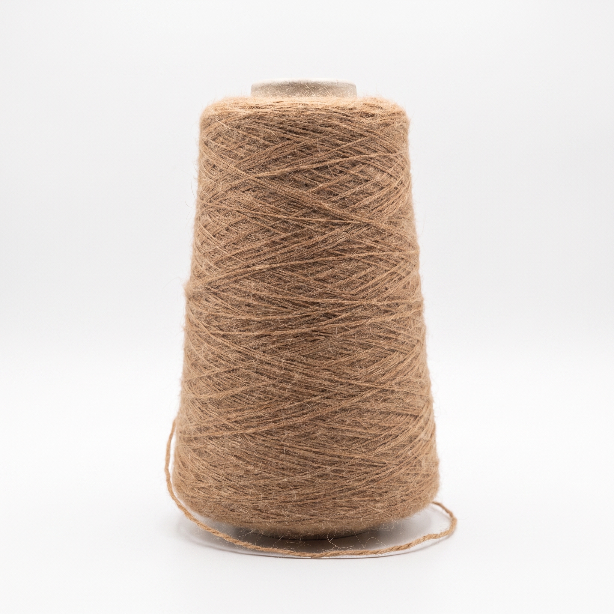 En cone med grovt, brunt garn står på en ljus yta.
