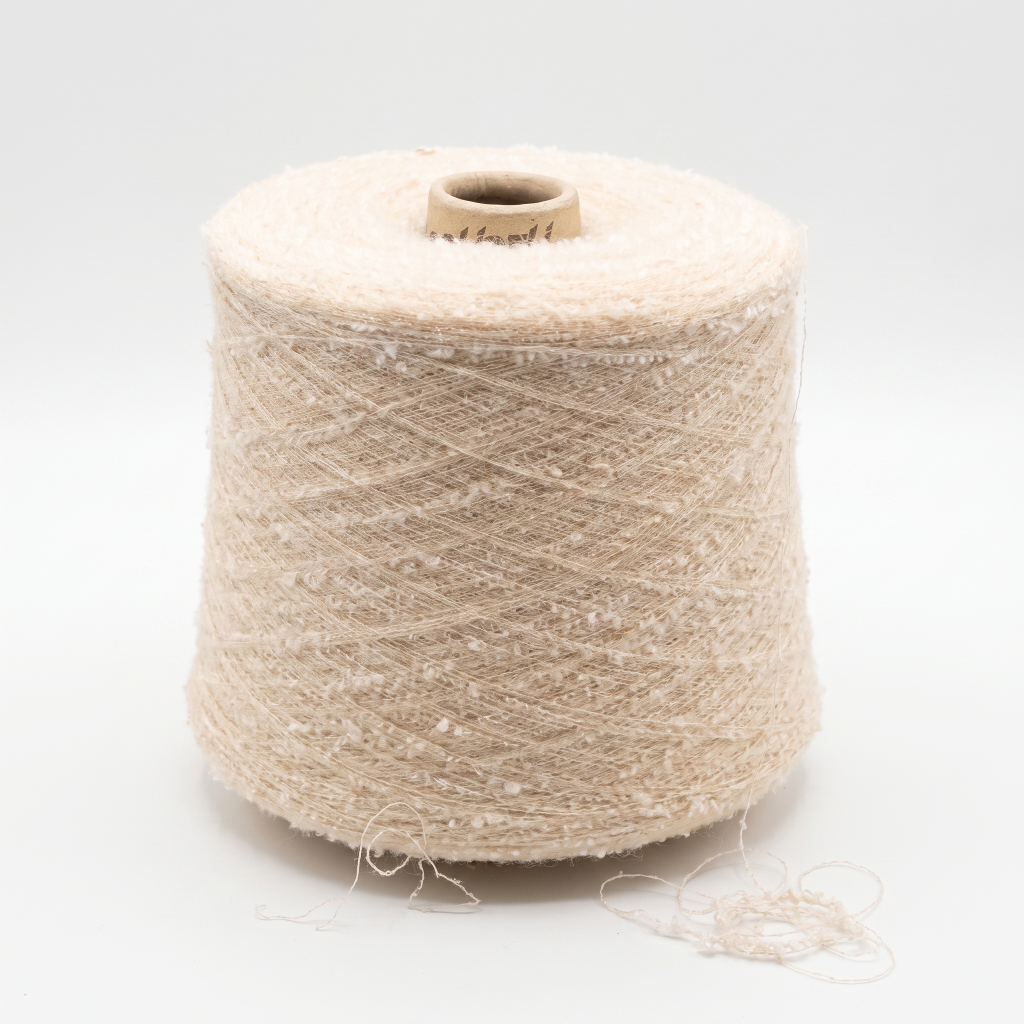 En stor cone med beige, texturerat garn på en ljus bakgrund.