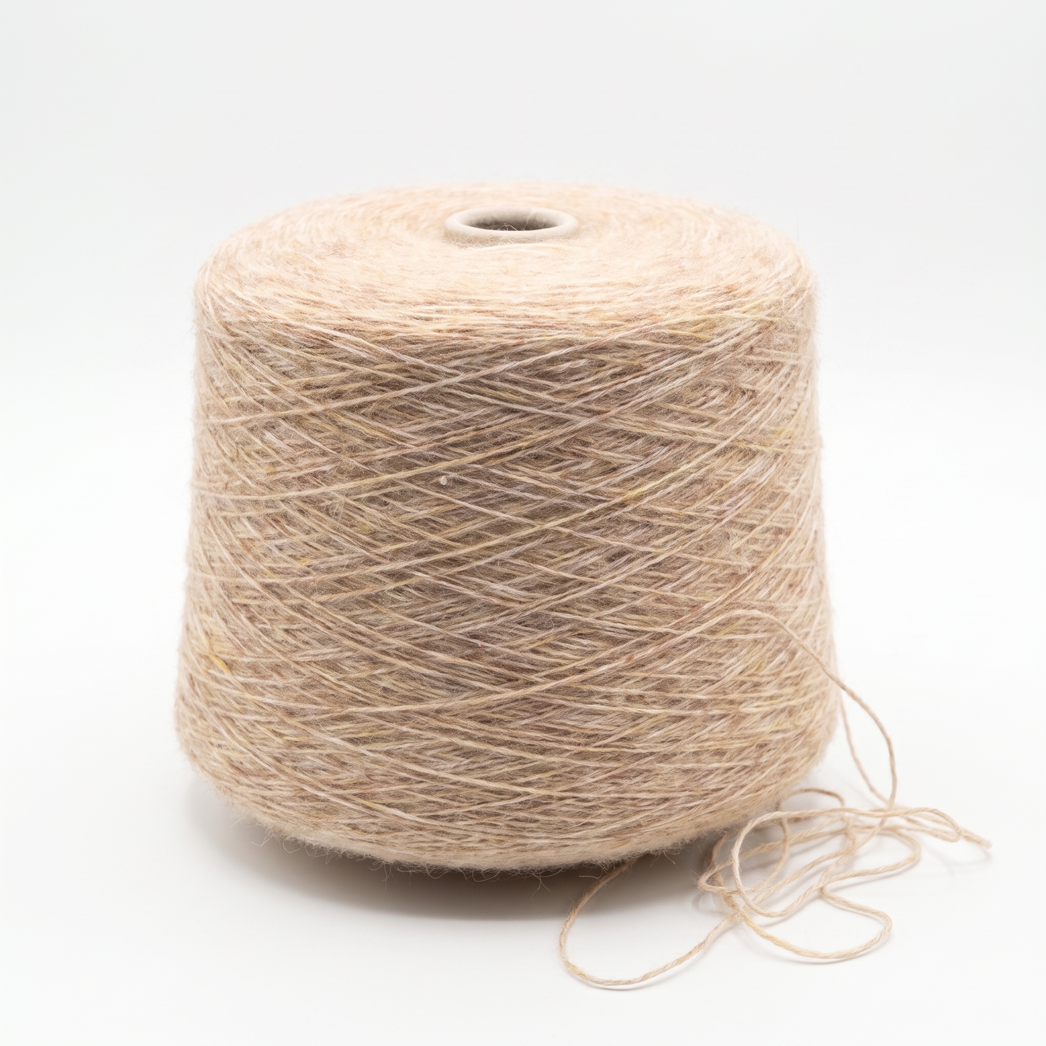 En stor cone med beige garn står på en vit bakgrund med en lös trådände vid basen.