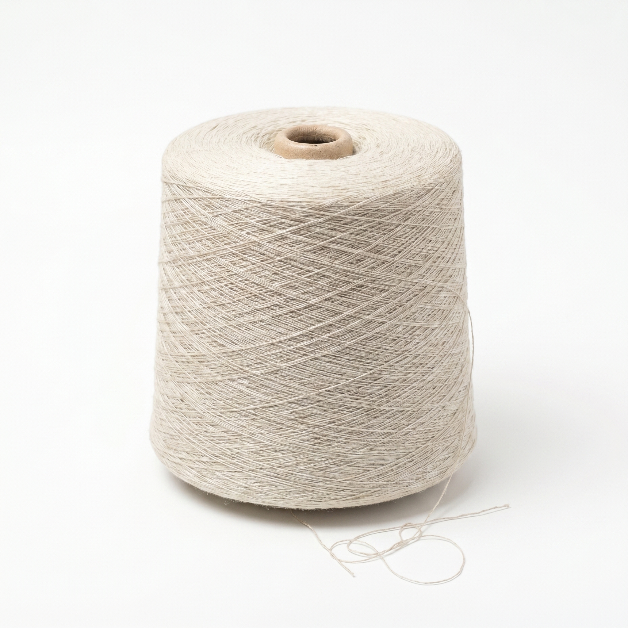 En stor cone av ljust beige garn mot en vit bakgrund.