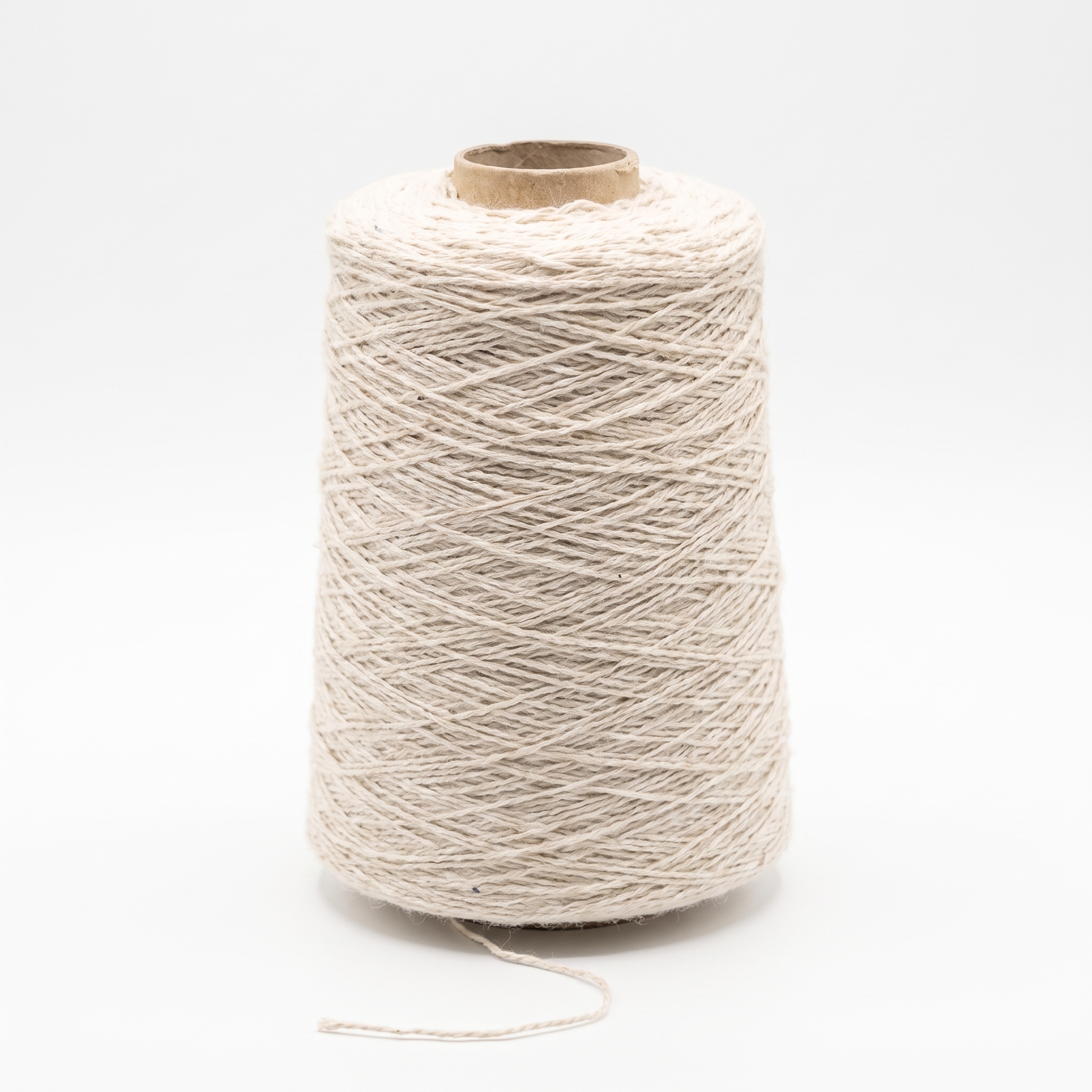 En stor cone med ljust, beige garn mot en vit bakgrund.