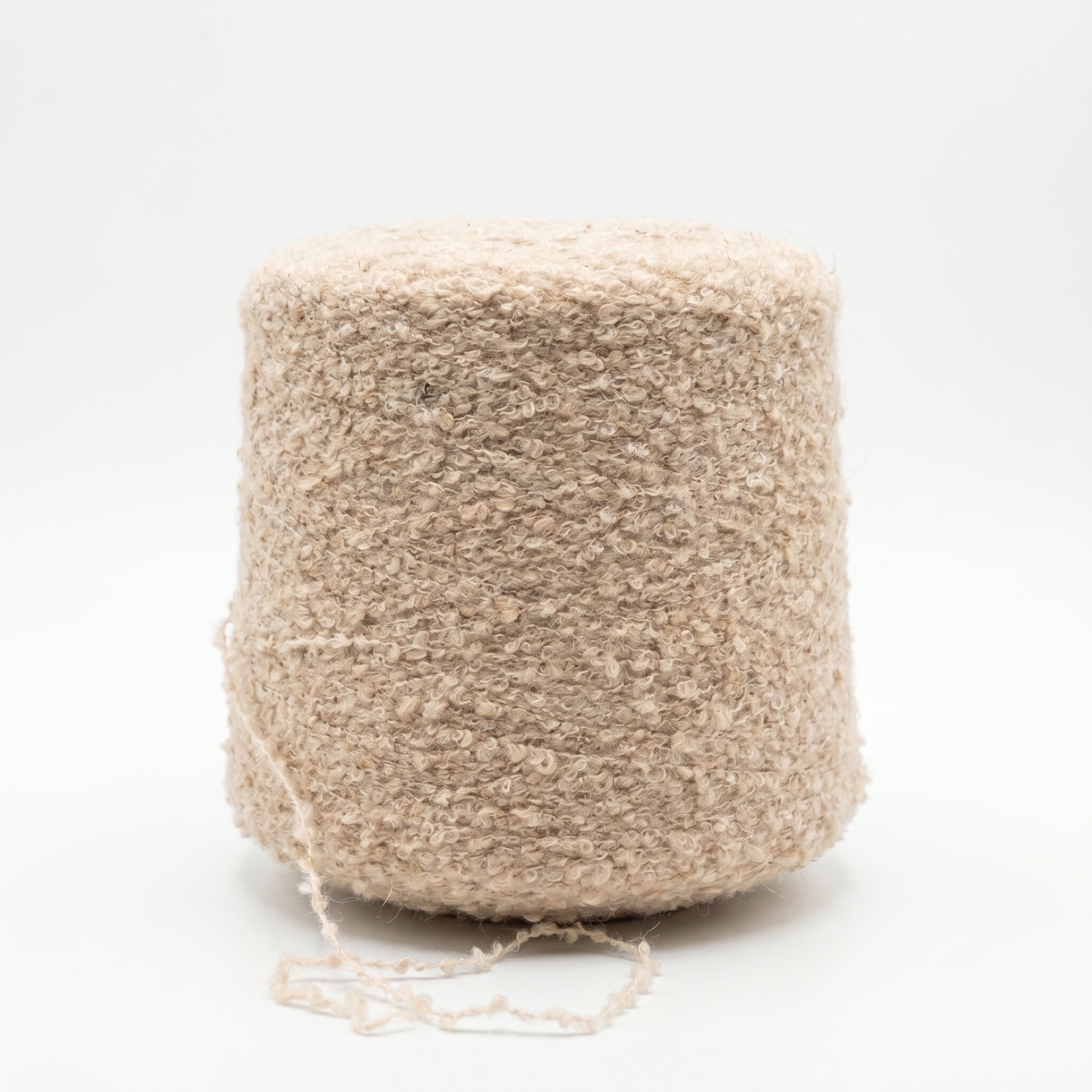 En bild av beige, texturerat garn lindat på en stor cone, med en lös tråd i botten mot en vit bakgrund.