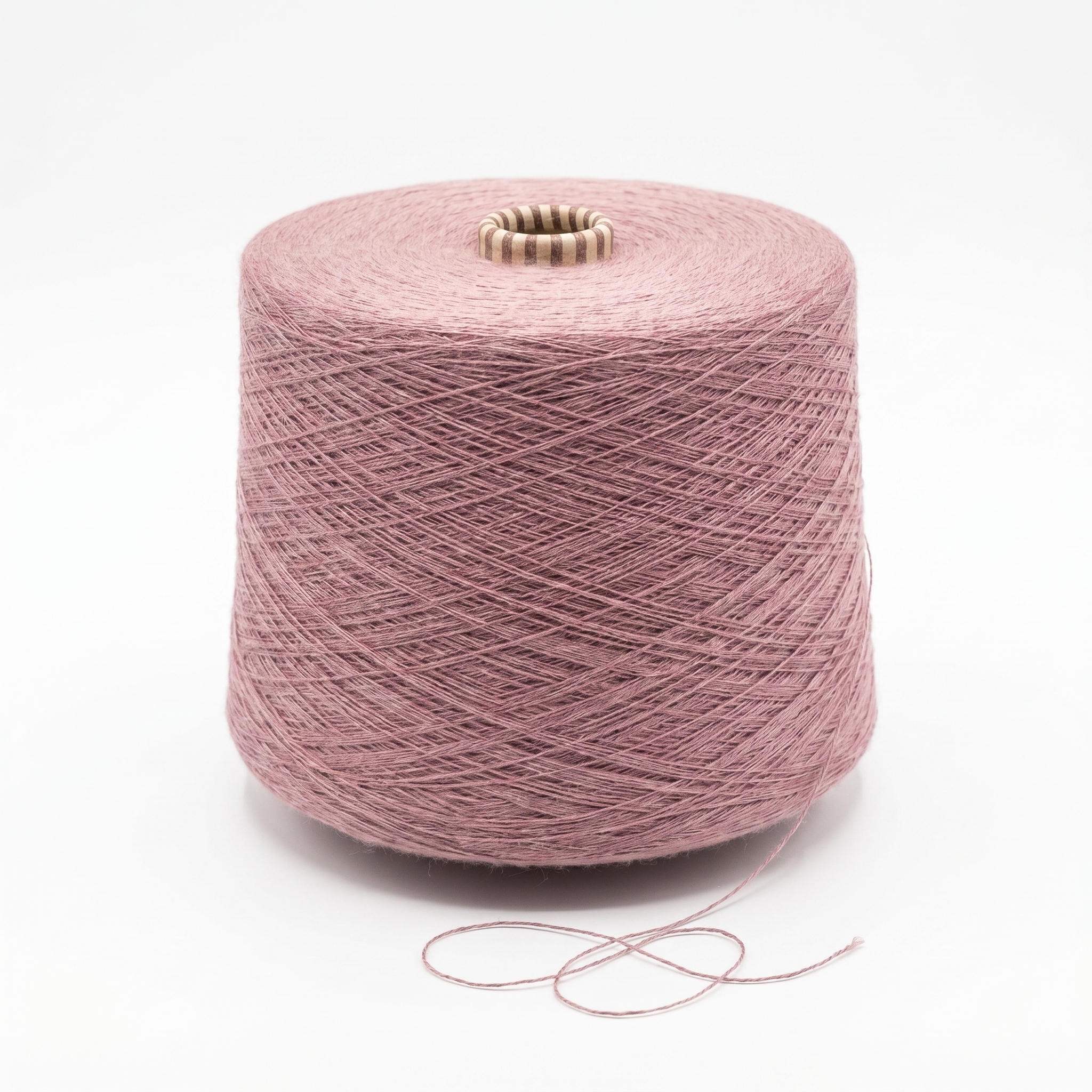 En stor cone med dovt rosa garn mot en vit bakgrund, med en lös trådände i botten.