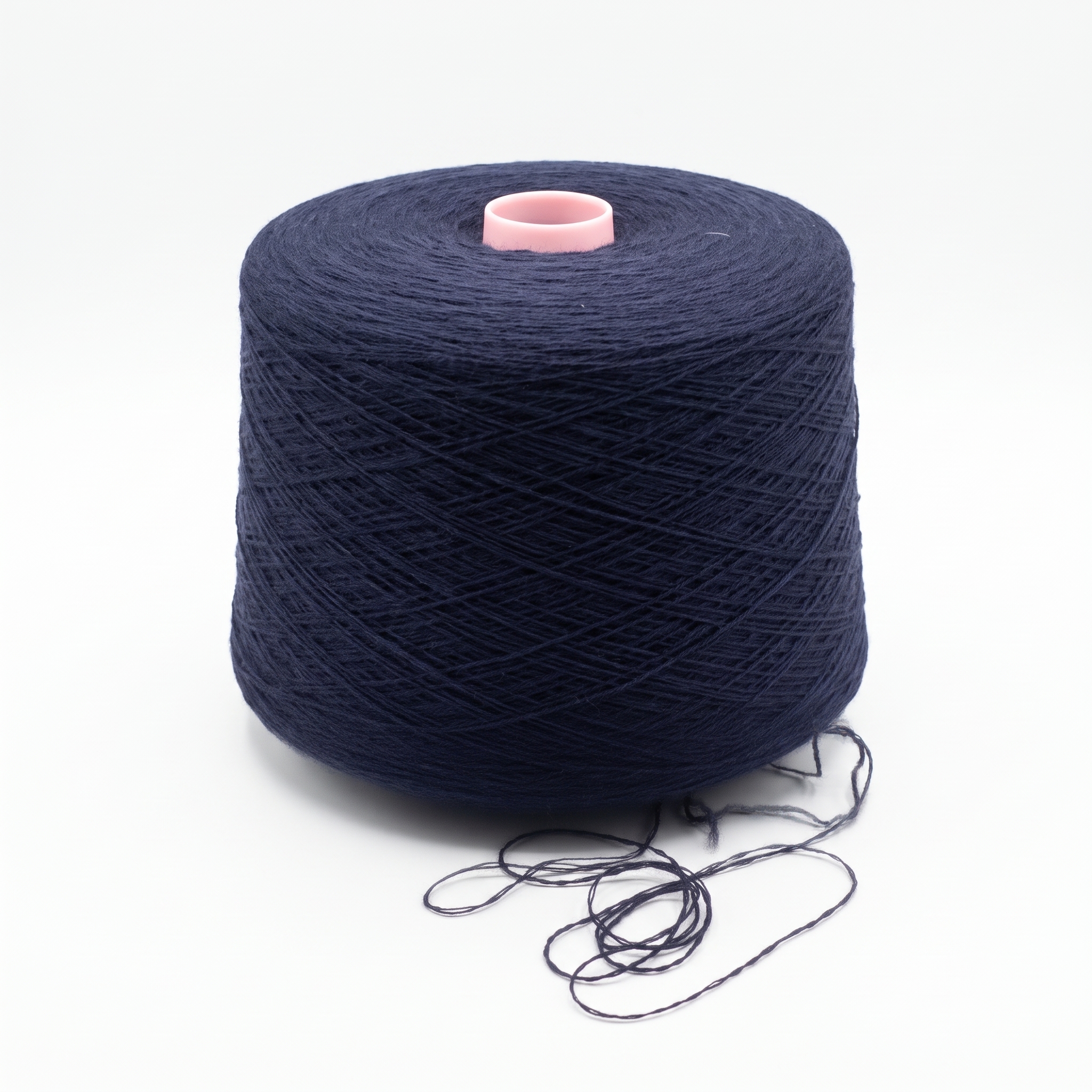 Mörkblått garn lindat på en cone med en rosa kärna synlig överst.