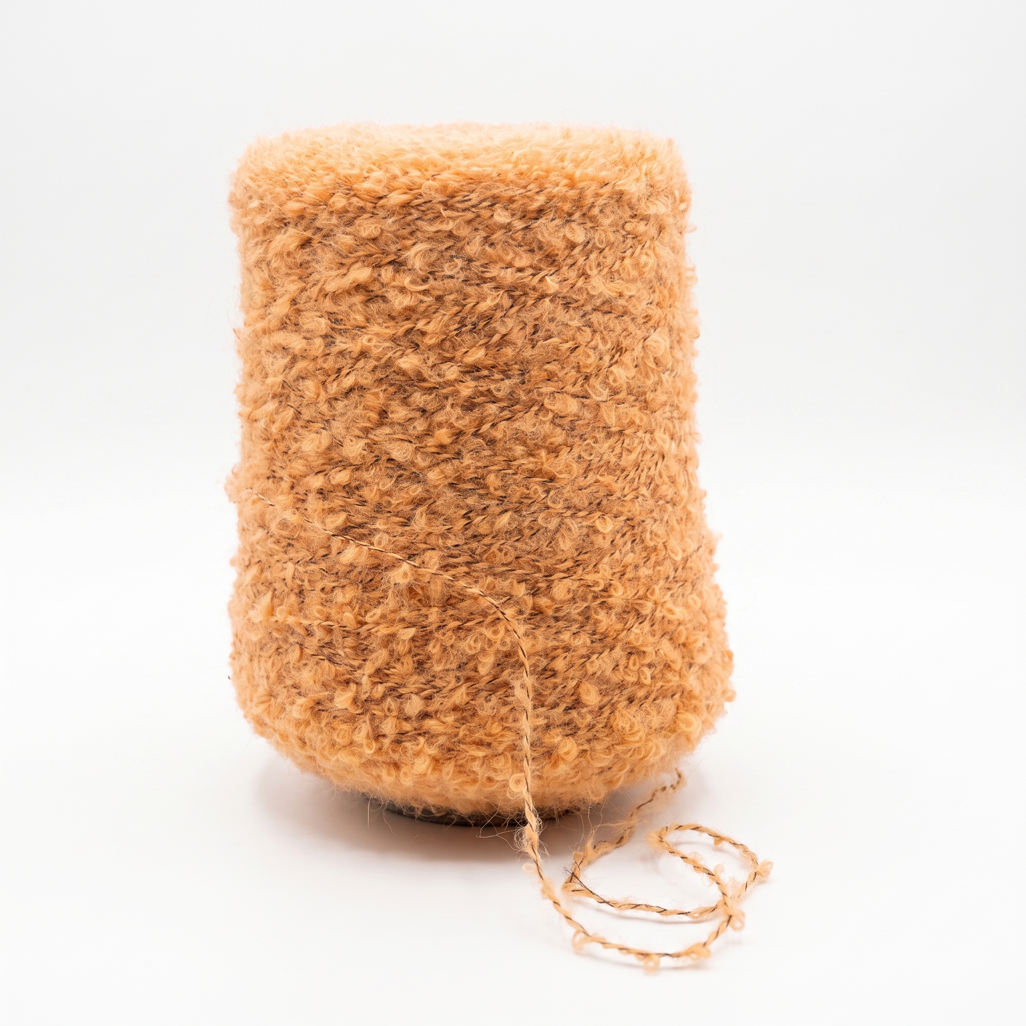 En cone med fluffigt, texturerat, ljusorange garn på en vit bakgrund.