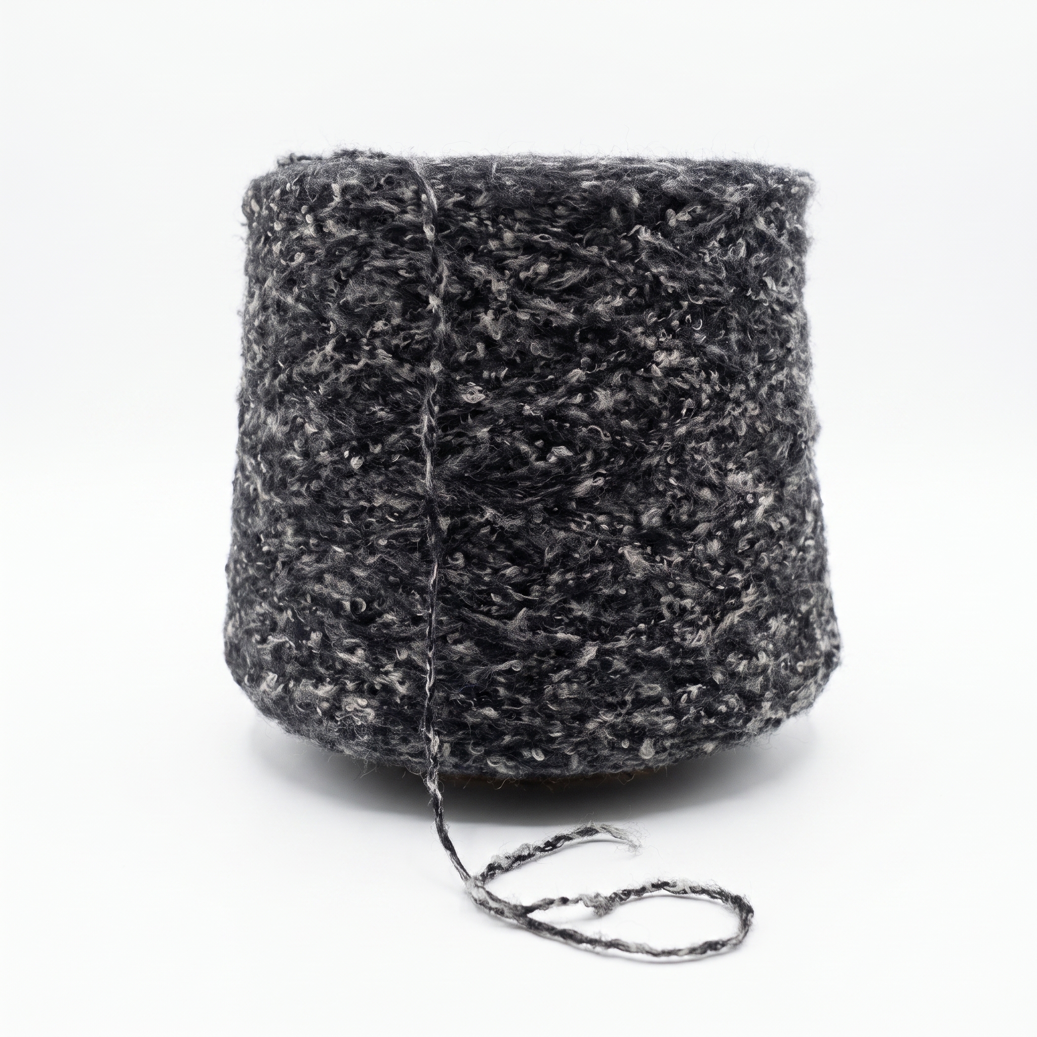 En cone av mörkgrått, texturerat garn med vita inslag.