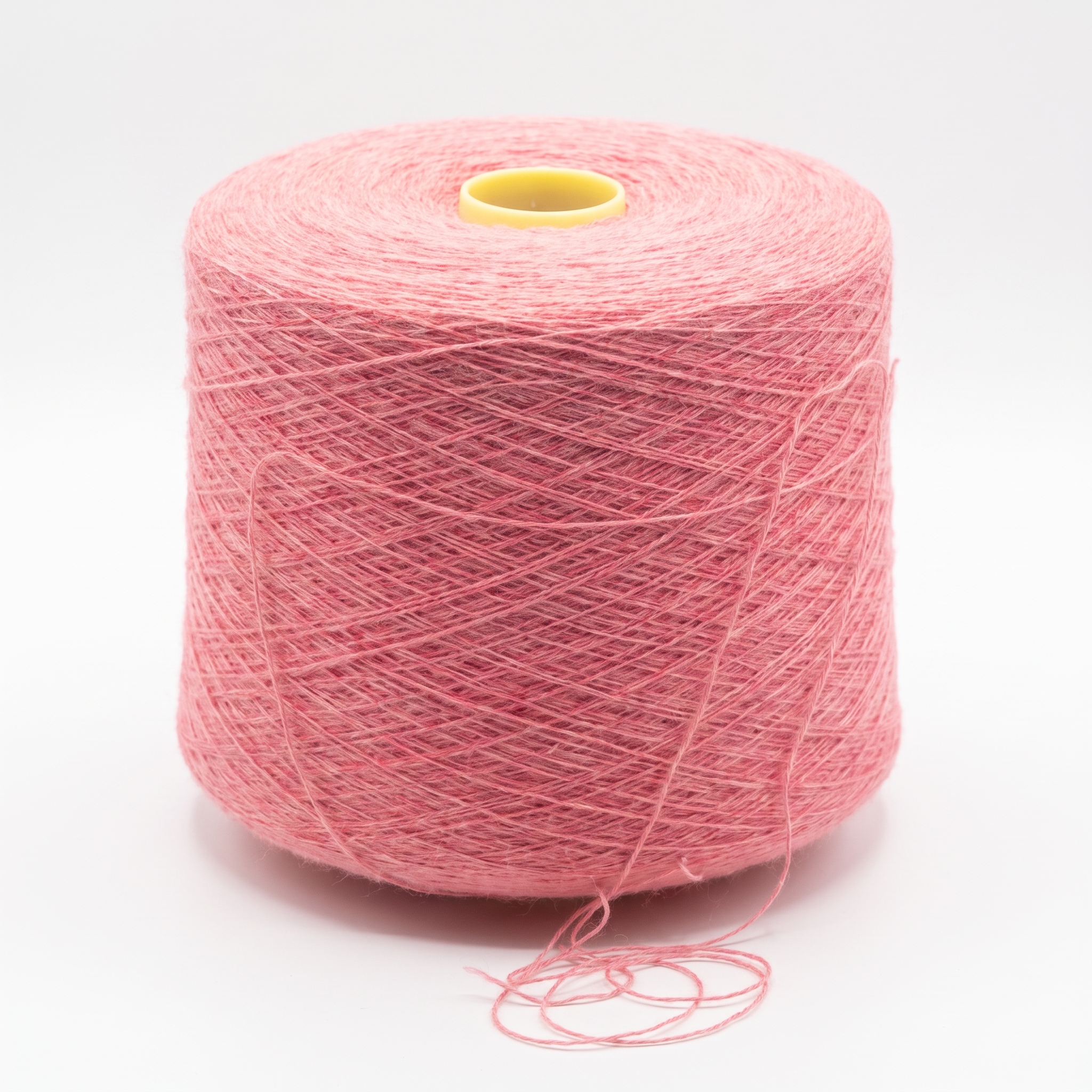 En stor cone med rosa garn på en vit bakgrund.