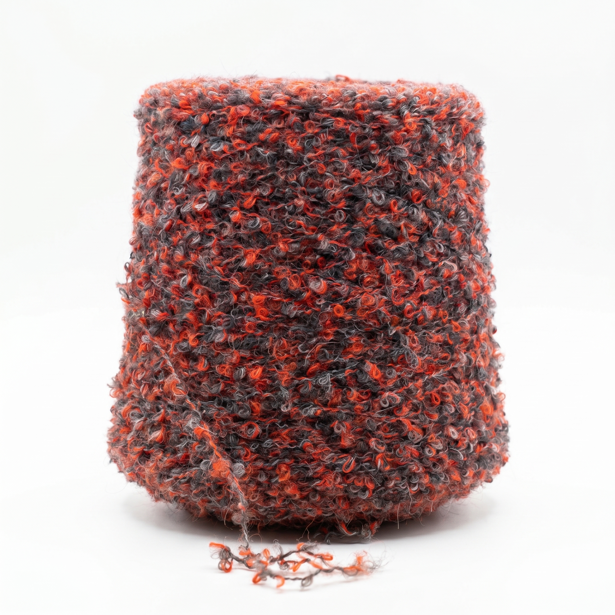 En stor cone med bouclégarn i orange och grå toner.