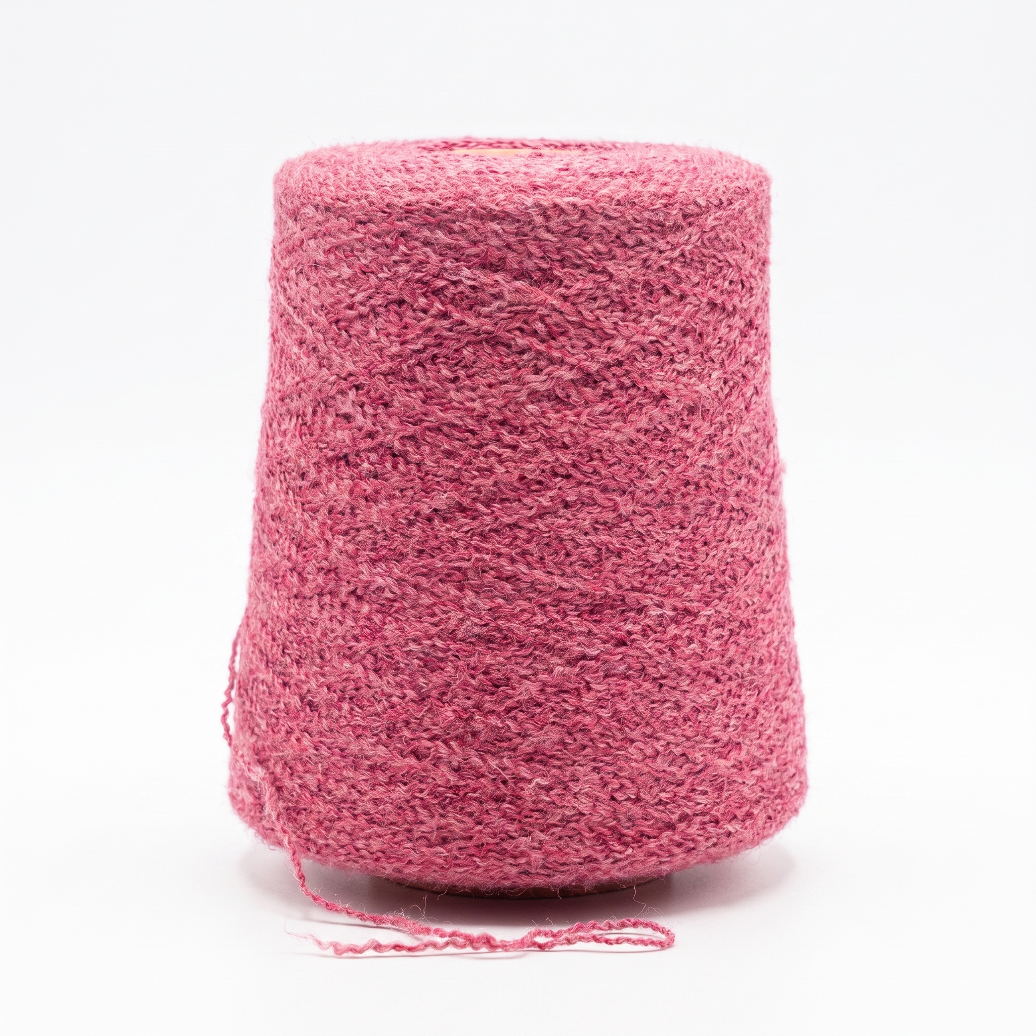 En stor cone med strukturerat rosa garn på en vit bakgrund.