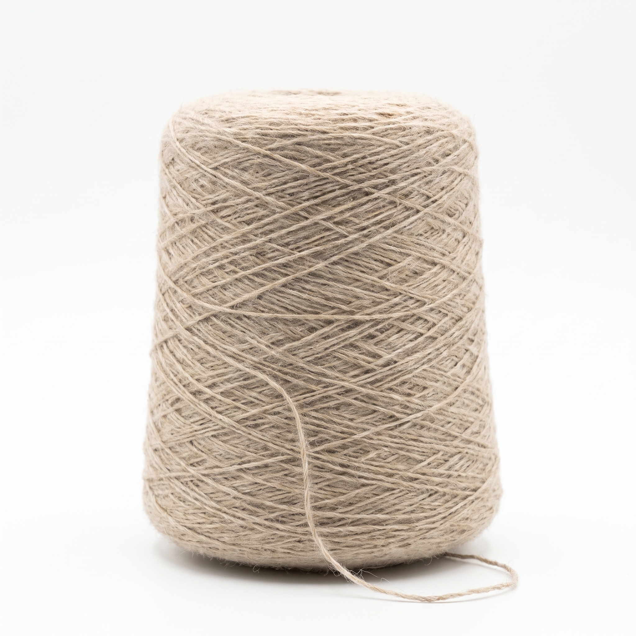 En cone med beige, grovt garn på en vit bakgrund.