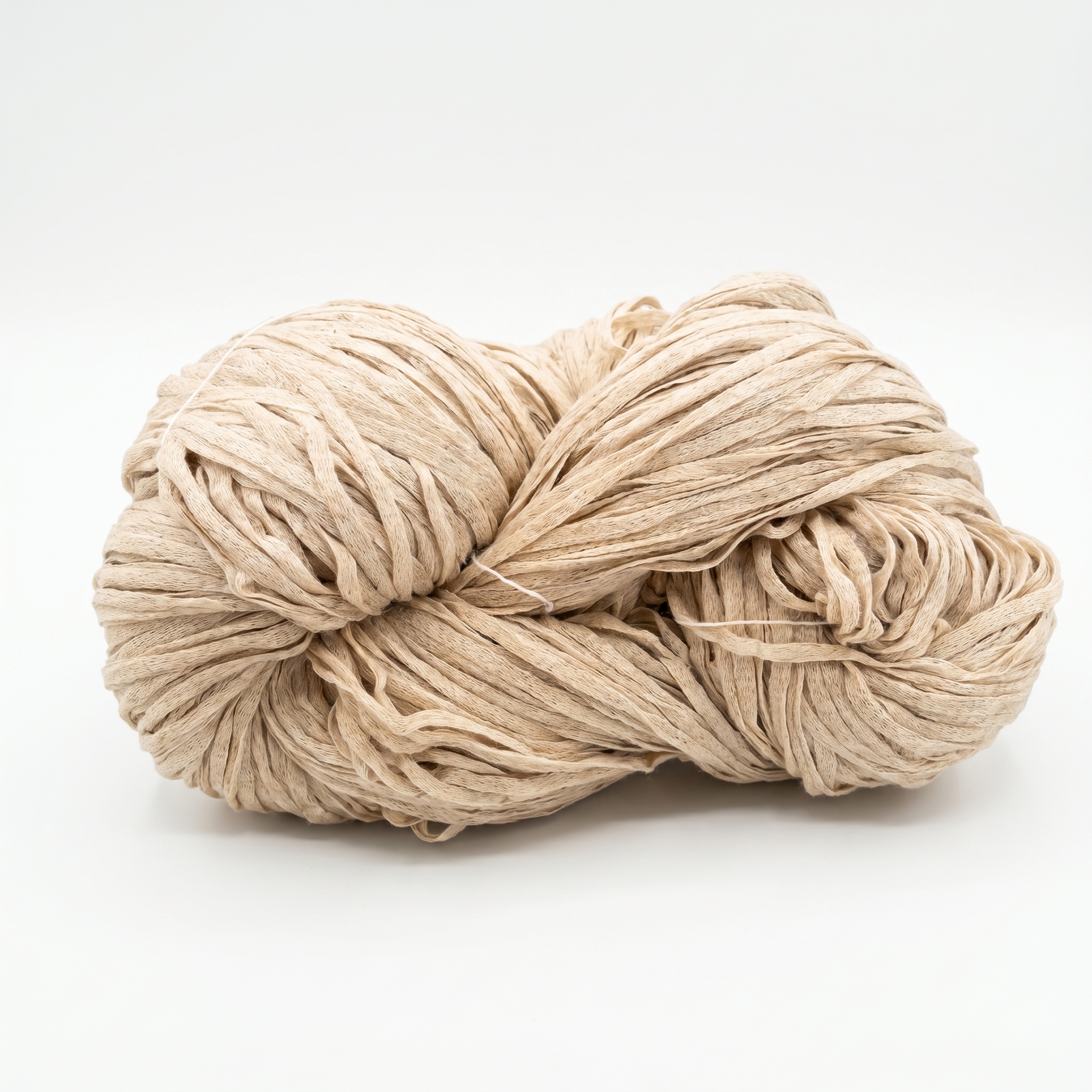 En härva av beige garn som liknar raffia, mot en vit bakgrund.