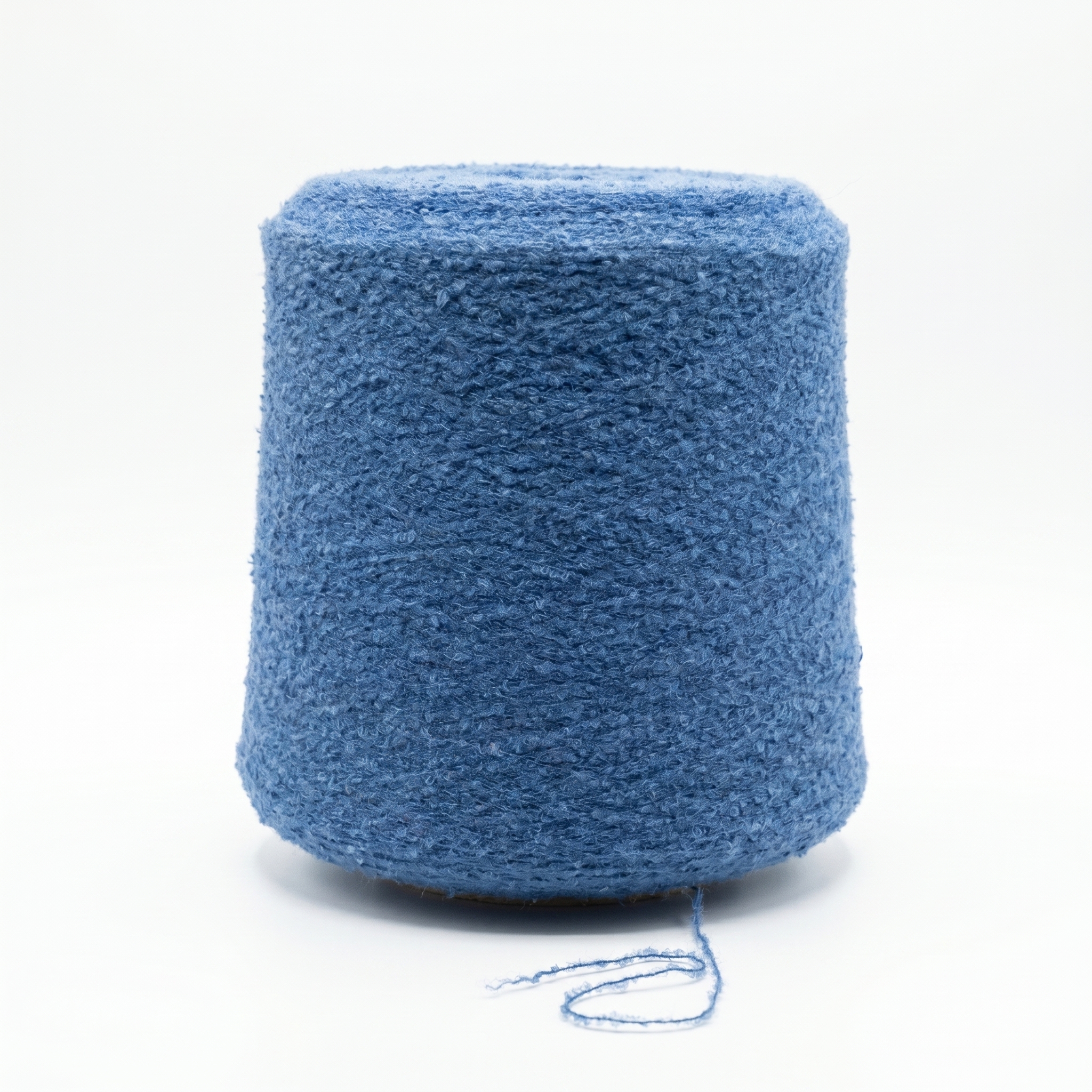 En cone med texturerat, blått garn mot en vit bakgrund.