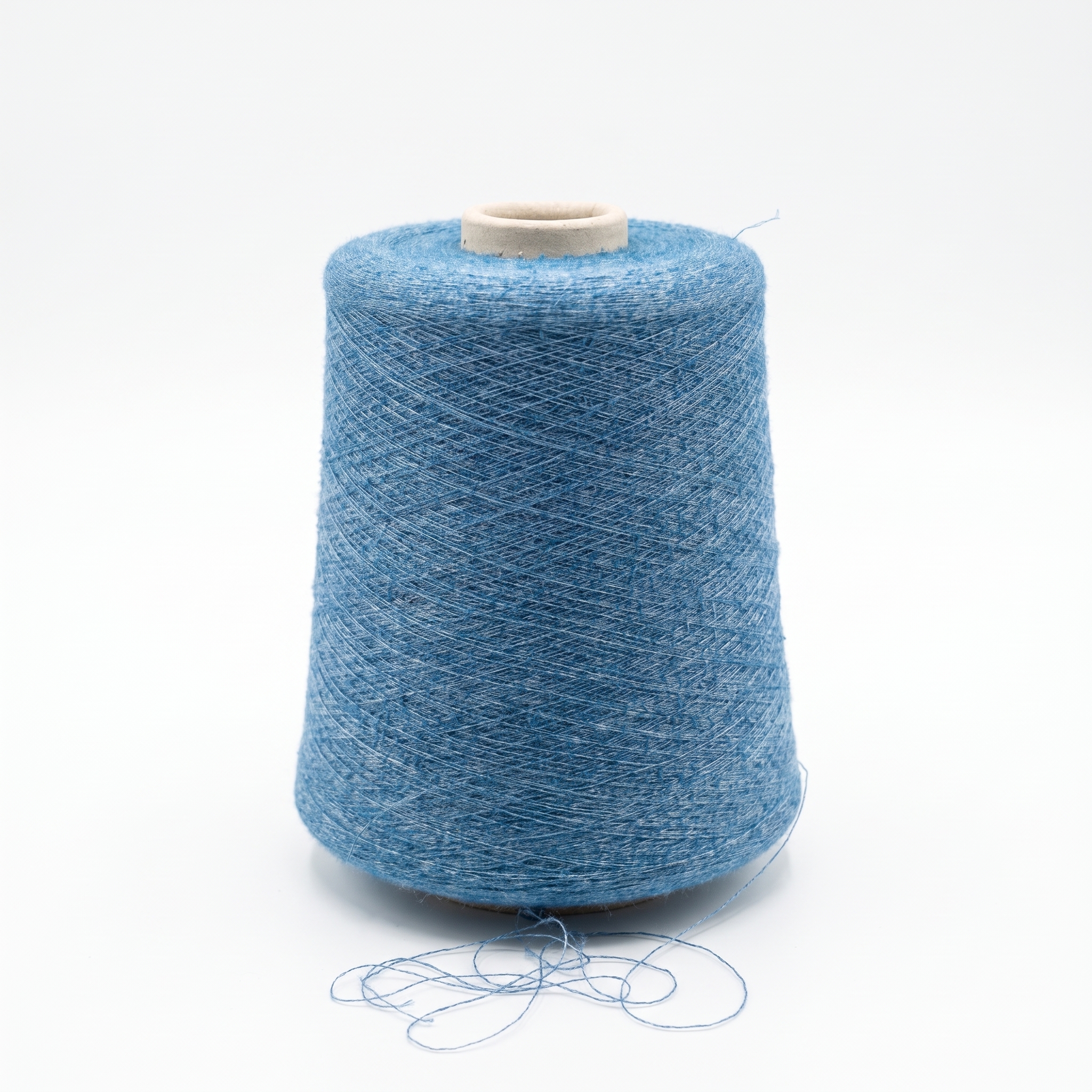 En cone med blått, texturerat garn mot en vit bakgrund.