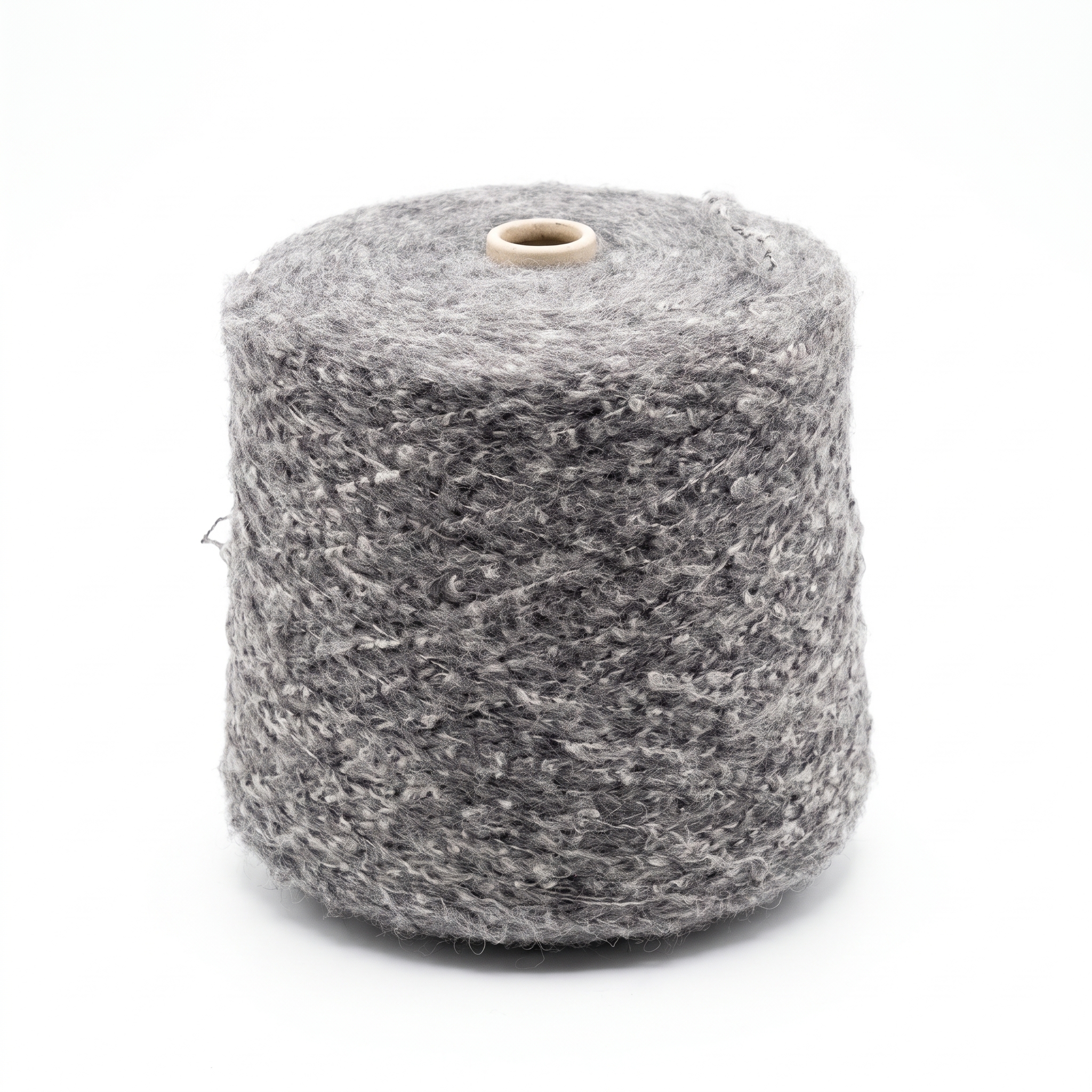 En stor cone med tjockt, texturerat grått garn mot en vit bakgrund.