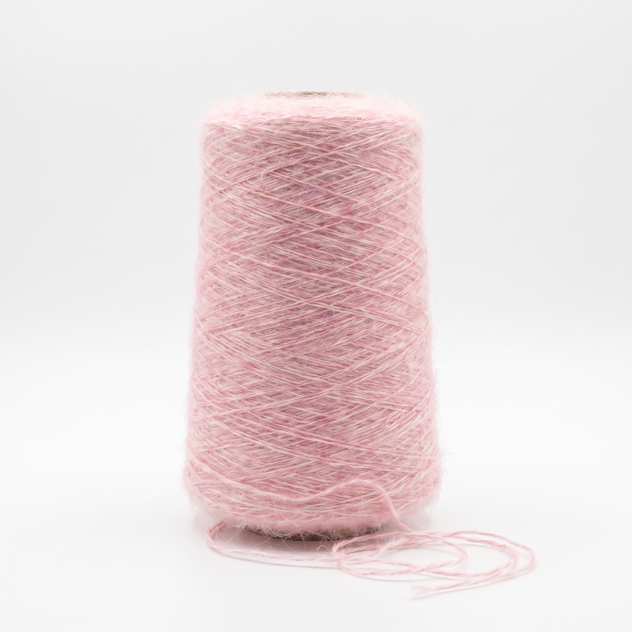 En cone med luddigt rosa garn mot en vit bakgrund.
