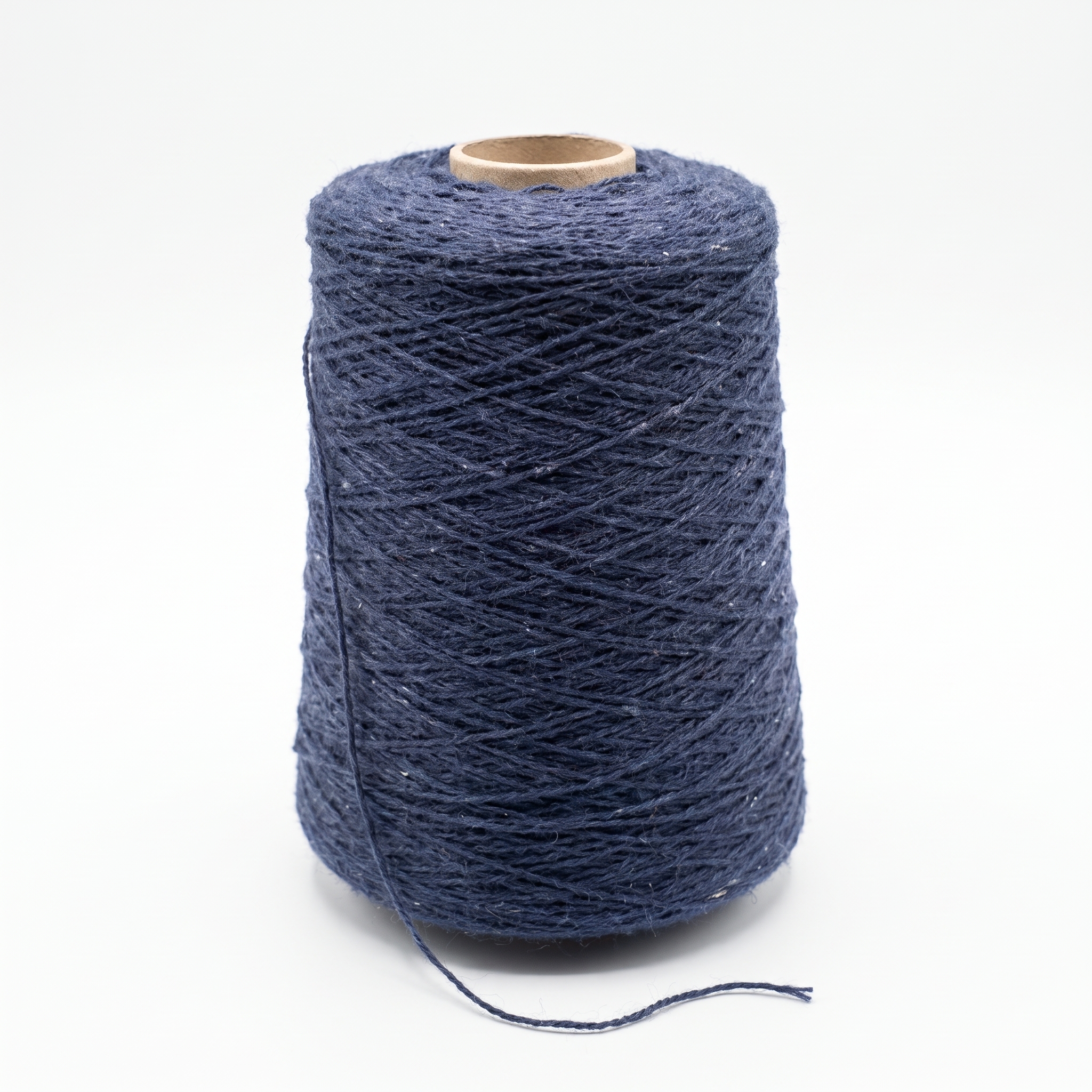 En stor cone av mörkblått garn med en lätt spräcklig textur, mot en vit bakgrund.