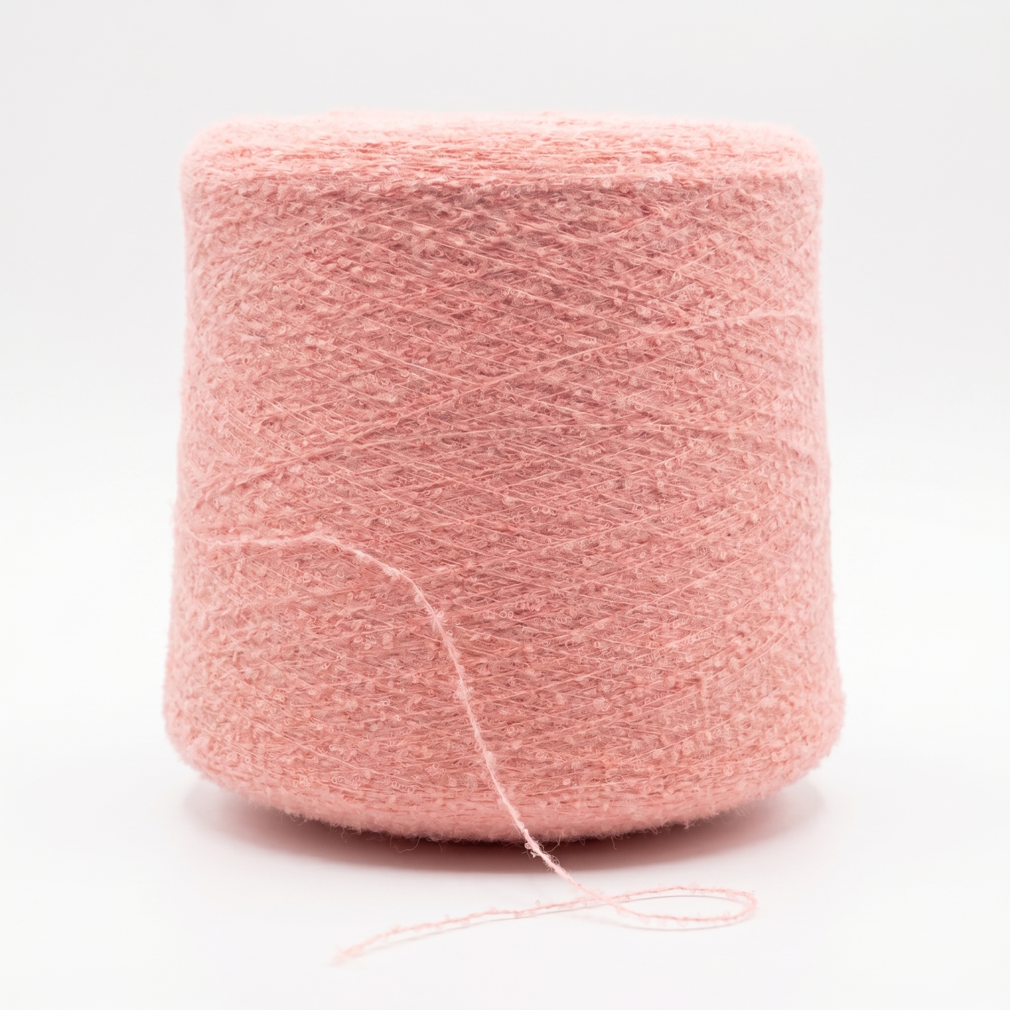 En stor cone med rosa, texturerat garn mot en vit bakgrund.
