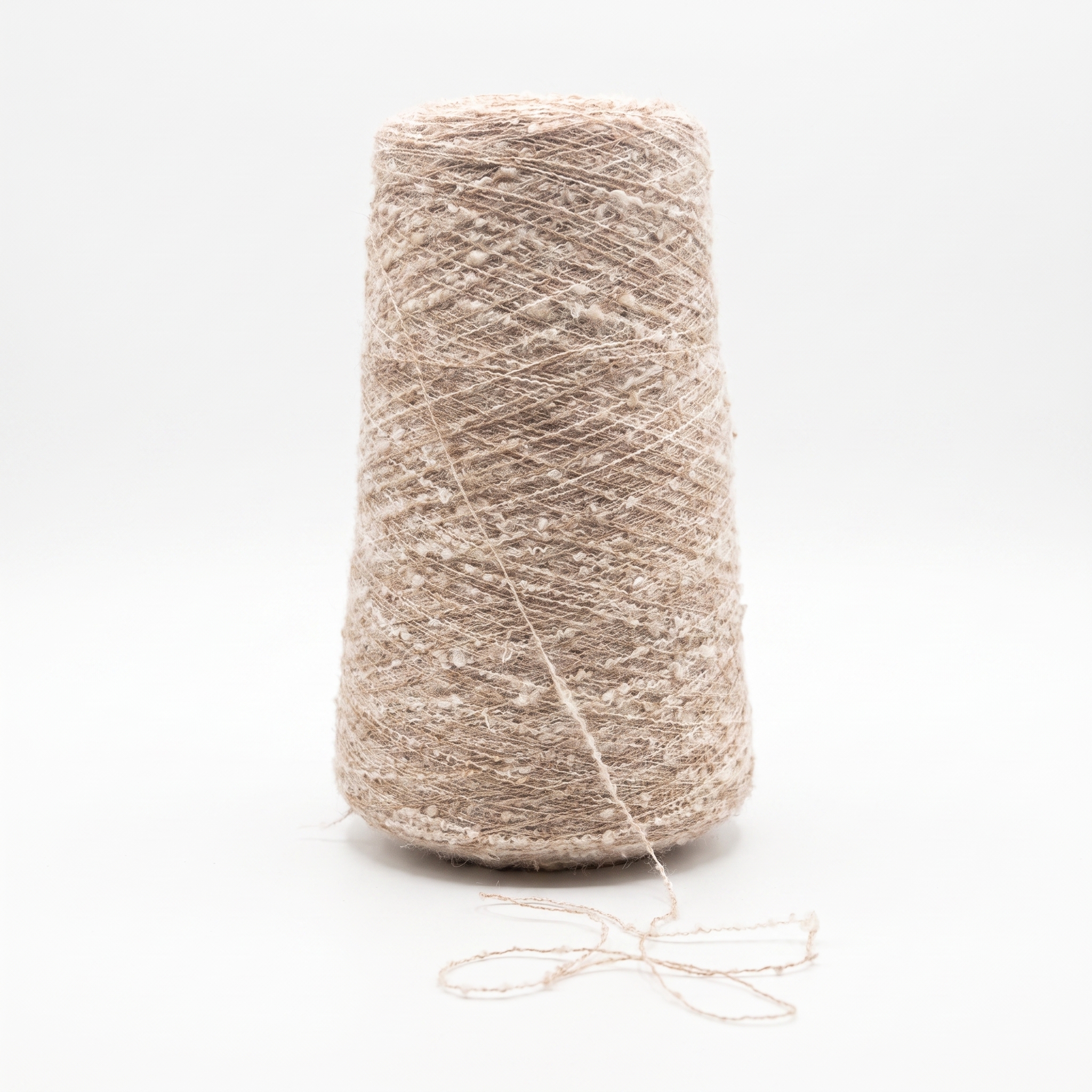 En cone med beige, texturerat garn mot en vit bakgrund.